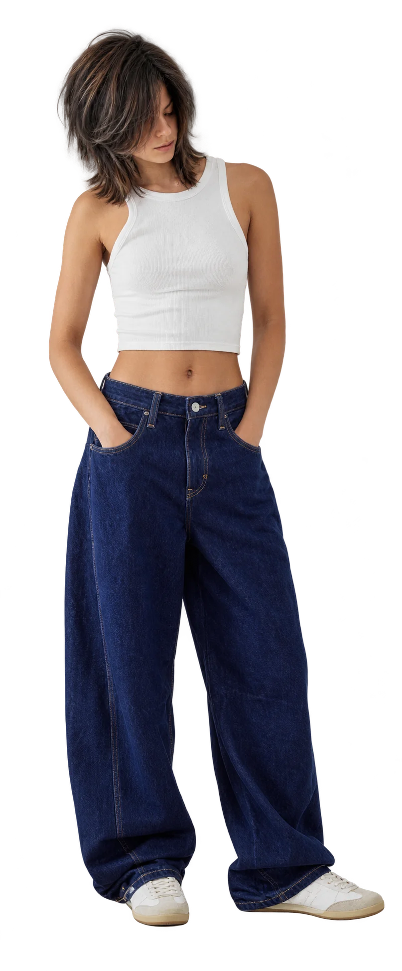 Model in a white vest and dark wide-leg jeans